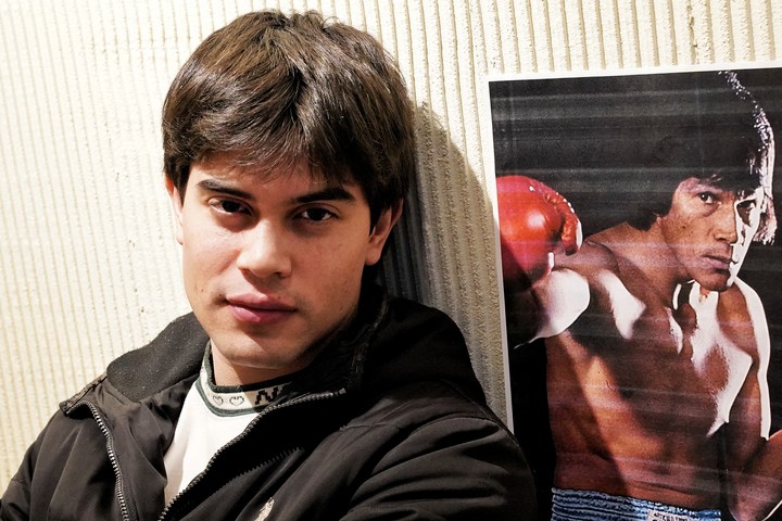 Agustín Monzón y un poster de su abuelo. No llegó a conocerlo, pero sus familiares le dicen que tiene muchas cosas de él. Foto: Martín Bonetto