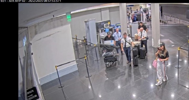 La gerenta de OCP TECH Laura Arrieta habla por celular en la zona de los escaners del aeroparque y luego se lo pasa a una funcionaria de la Aduana.