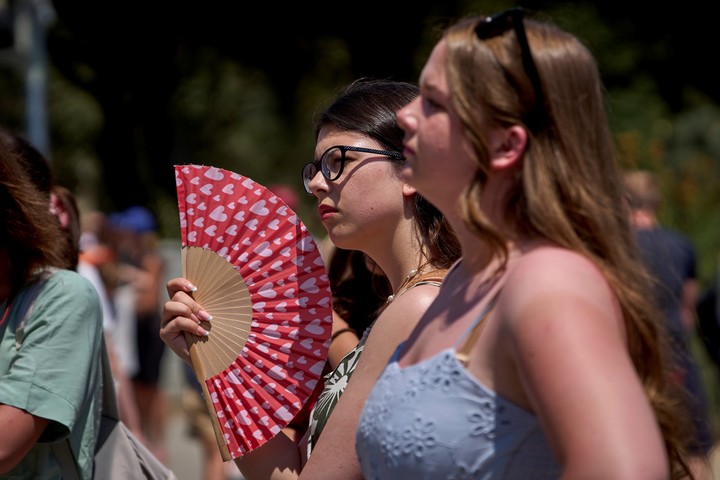 Jóvenes enfrentan el calor durante una visita a la Sagrada Familia, en Barcelona. Foto: AP