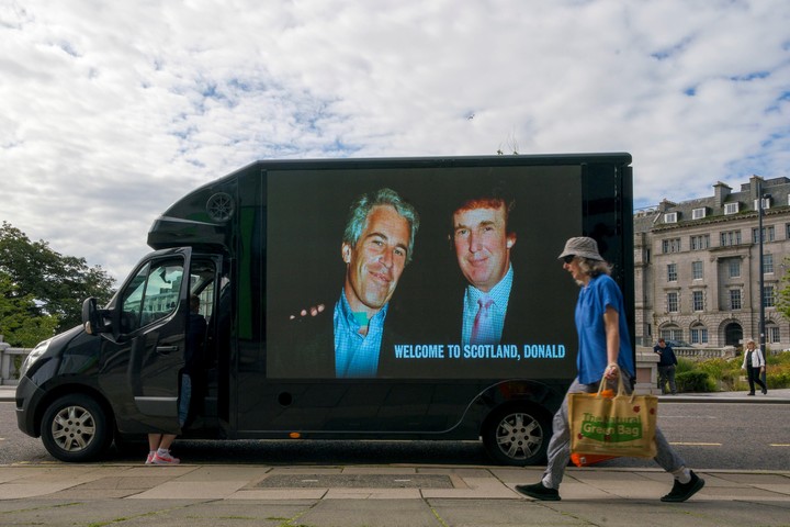Una fotografía del presidente estadounidense Donald Trump y Jeffrey Epstein se exhibe en el lateral de una furgoneta en el centro de la ciudad de Aberdeen, durante el viaje privado de cinco días del presidente estadounidense Donald Trump a Escocia, el lunes 28 de julio de 2025. (Jane Barlow/PA vía AP)