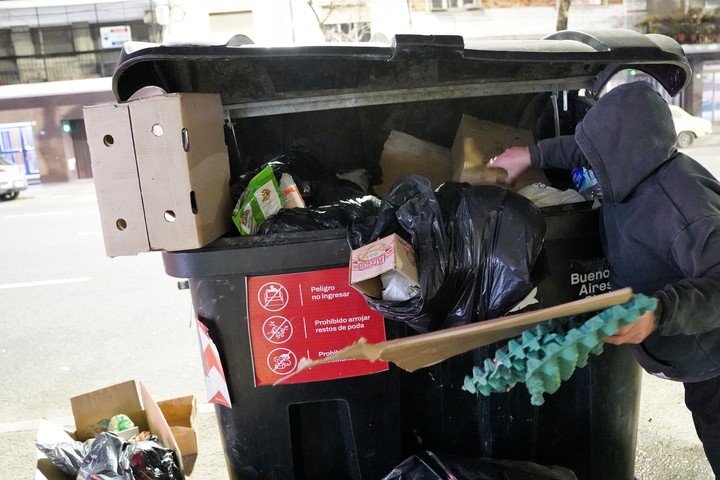 "Tengo hambre". Es lo que se limitó a decir una persona en Balvanera, mientras revolvía un contenedor. Foto Martín Bonetto 